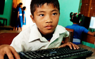Un enfant hagard devant un ordinateur en ligne