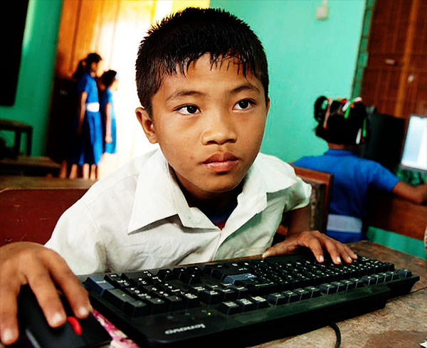 Un enfant hagard devant un ordinateur en ligne