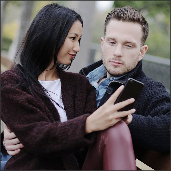 une femme montre son smartphone a son petit copain