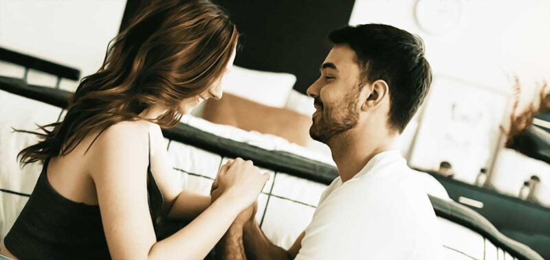 Couple souriant se tenant par les mains.