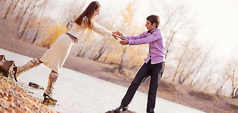 Couple s'amusant au bord de l'eau, testant leur confiance réciproque.