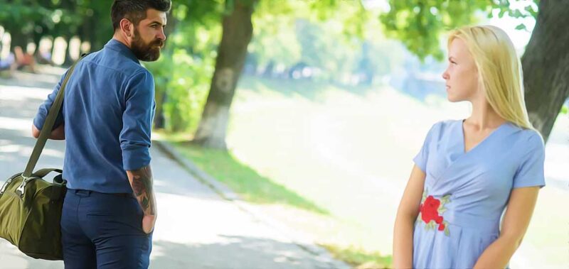 Homme et femme se croisent dans un parc.