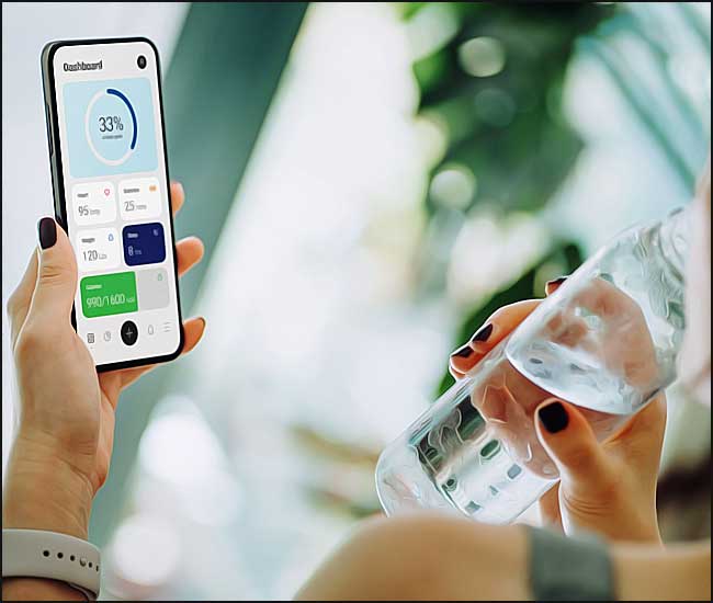 Une femme svelte boit de l'eau et utilise une application mobile