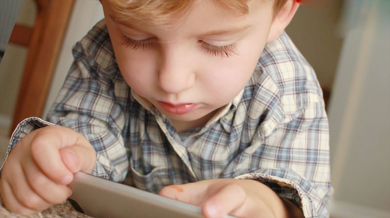 Jeune enfant (fils) sur son téléphone
