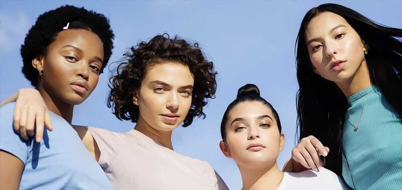 Quatre jeunes femmes diversifiées en extérieur.