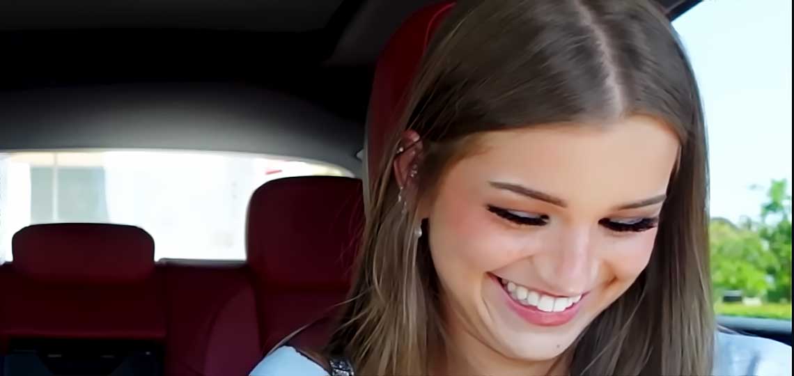 Jeune femme souriante dans une voiture (Brooke Monk)
