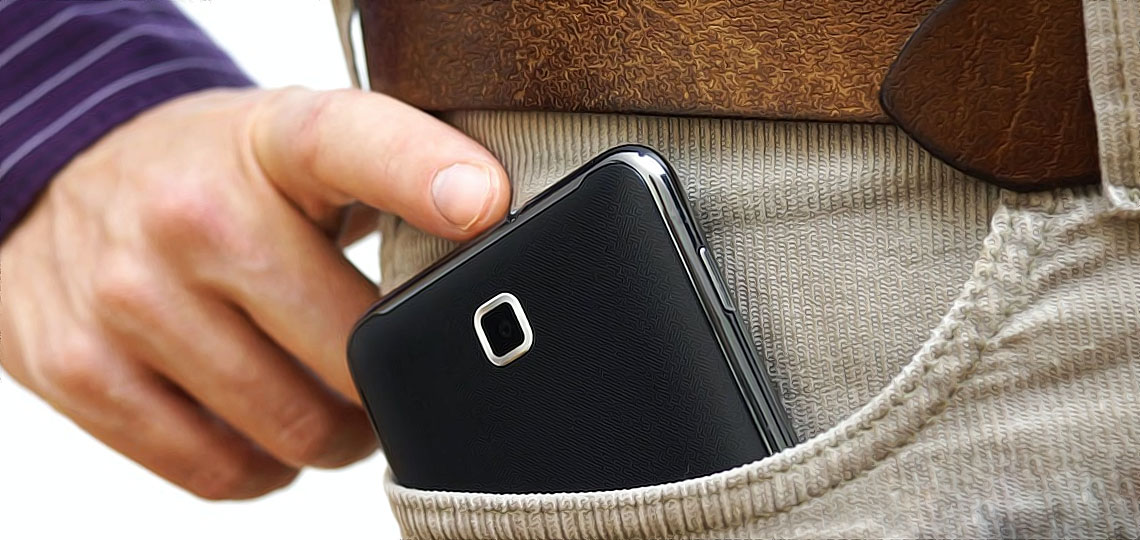 un homme met son telephone portable dans sa poche