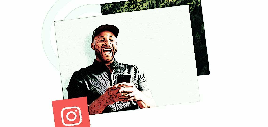 un homme noir heureux tient son telephone en main avec un logo instagram