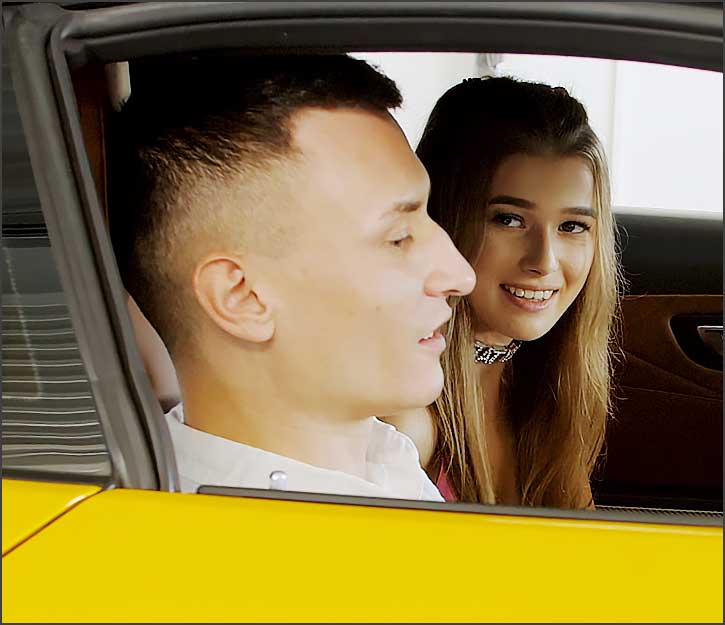 Homme et femme souriants dans une voiture.