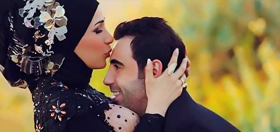 Couple s'embrassant en tenue de mariage traditionnelle musulmane.