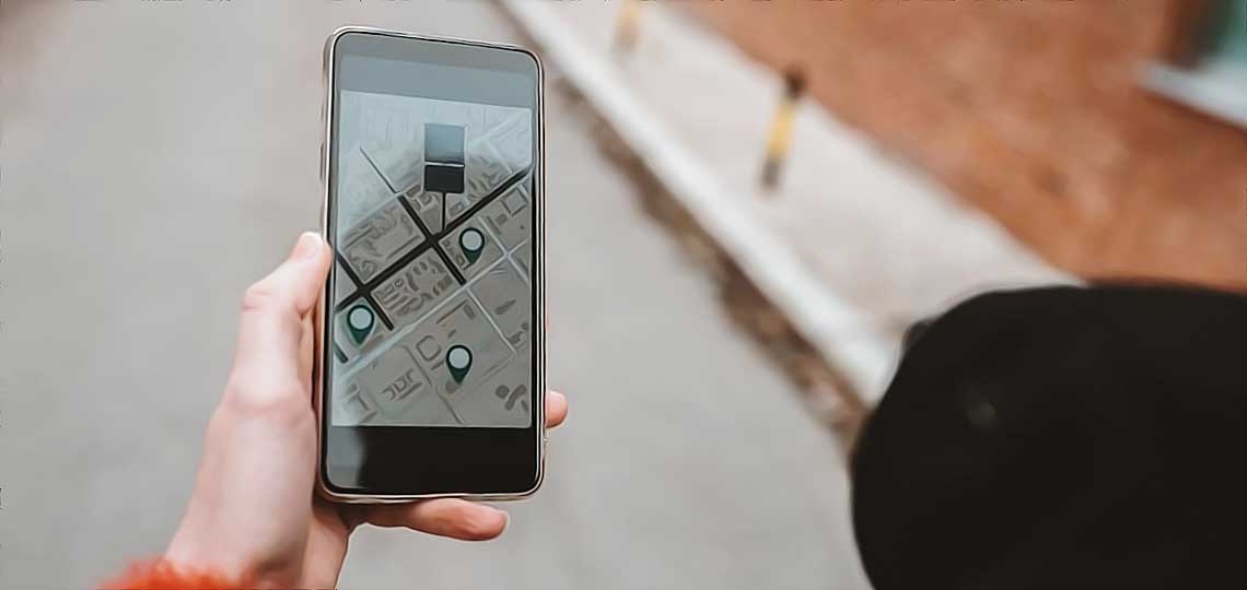 Main tenant un smartphone et affichant une cartographie urbaine.