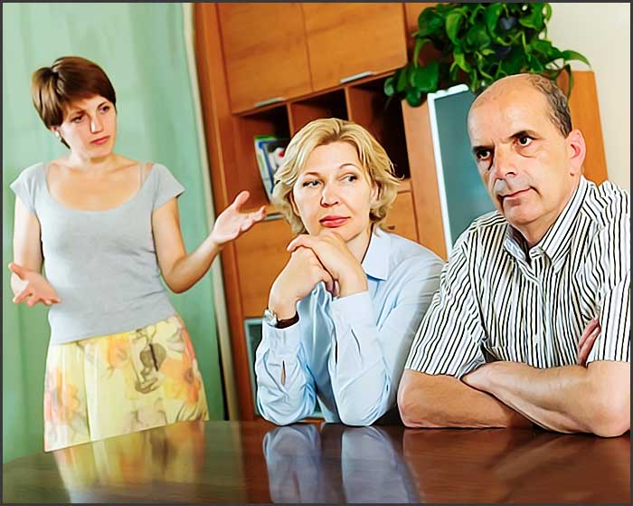 Trois personnes semblant avoir une discussion sérieuse.