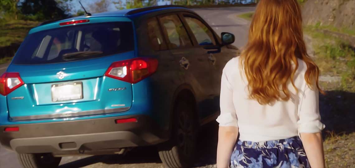 femme rousse devant une voiture